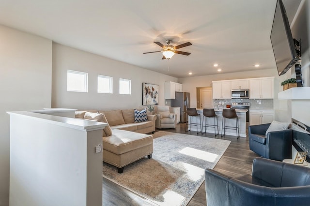 living area with recessed lighting, dark wood-style floors, and a ceiling fan