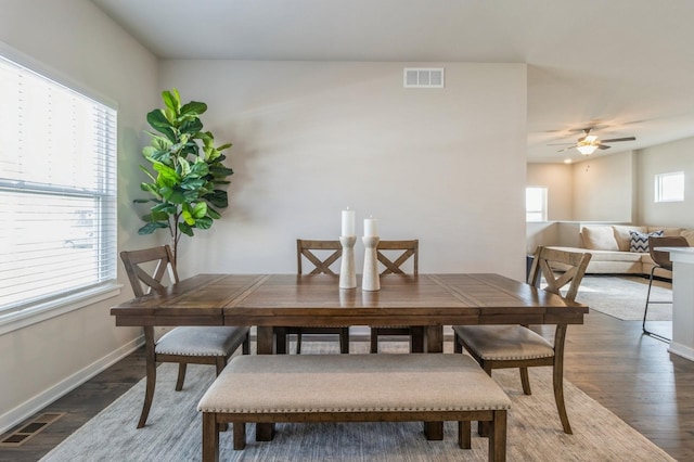 dining space with visible vents, plenty of natural light, dark wood-type flooring, and baseboards