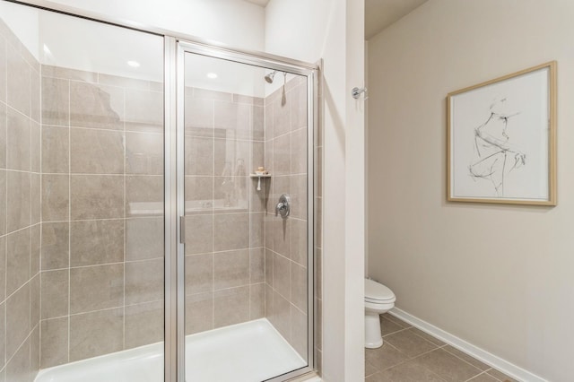 full bath featuring baseboards, toilet, a stall shower, and tile patterned flooring