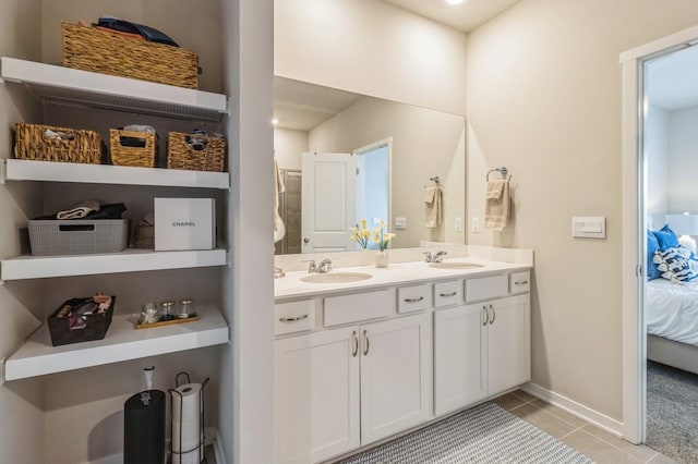 bathroom with a sink, connected bathroom, double vanity, and tile patterned flooring