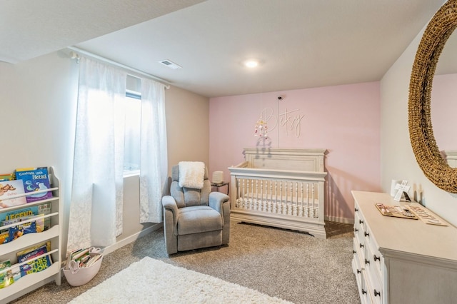 bedroom featuring baseboards, visible vents, a crib, and carpet floors