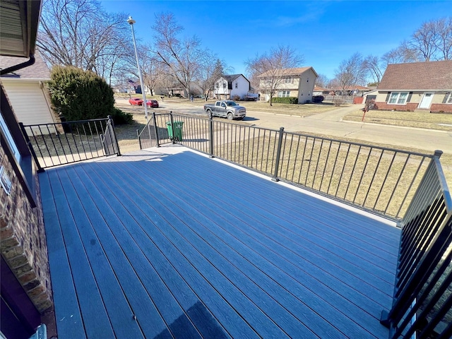 wooden terrace featuring a yard and a residential view