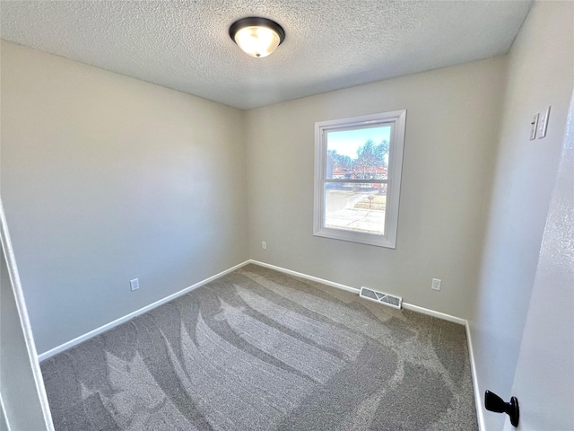 empty room featuring visible vents, baseboards, carpet, and a textured ceiling