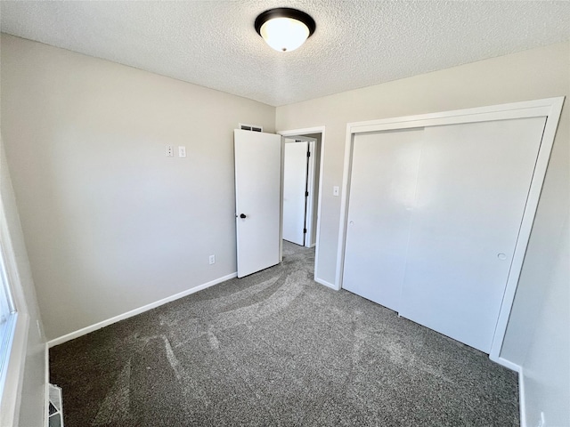 unfurnished bedroom featuring carpet flooring, baseboards, a closet, and a textured ceiling