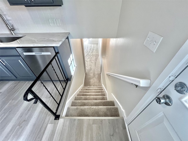 staircase with baseboards and wood finished floors