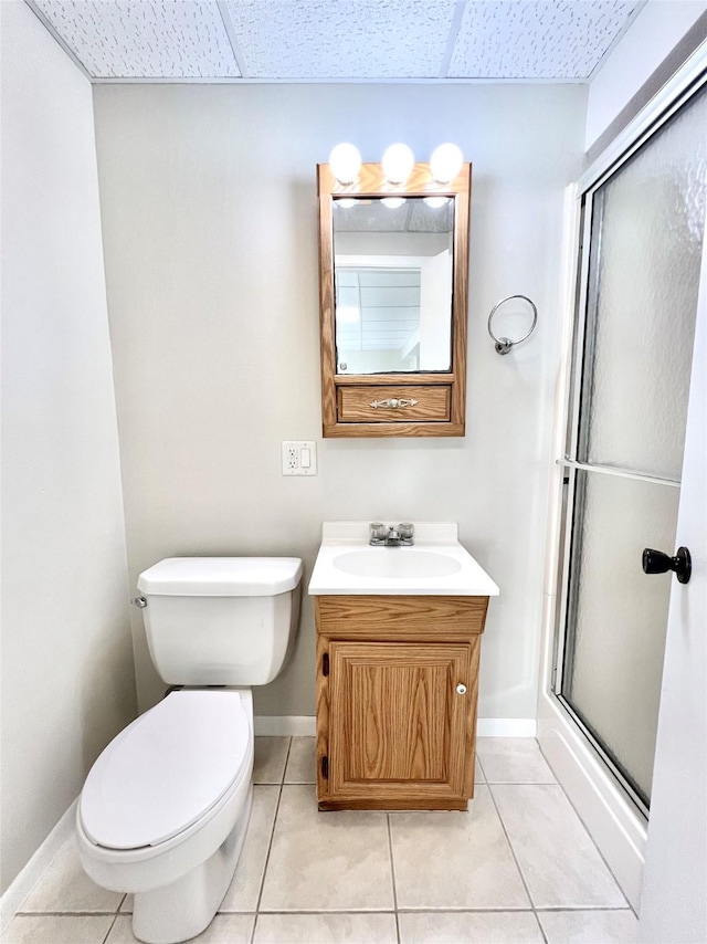 full bathroom with toilet, tile patterned floors, an enclosed shower, and a paneled ceiling