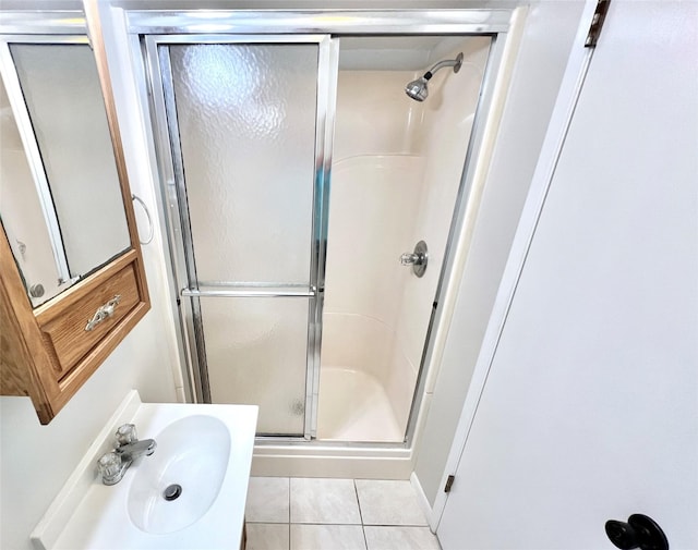 bathroom featuring a sink, a shower stall, and tile patterned flooring