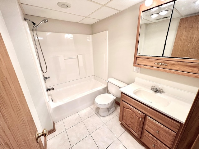 bathroom with vanity, shower / tub combination, a drop ceiling, tile patterned floors, and toilet