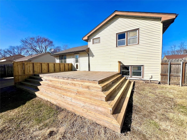 rear view of house with a fenced backyard and a deck