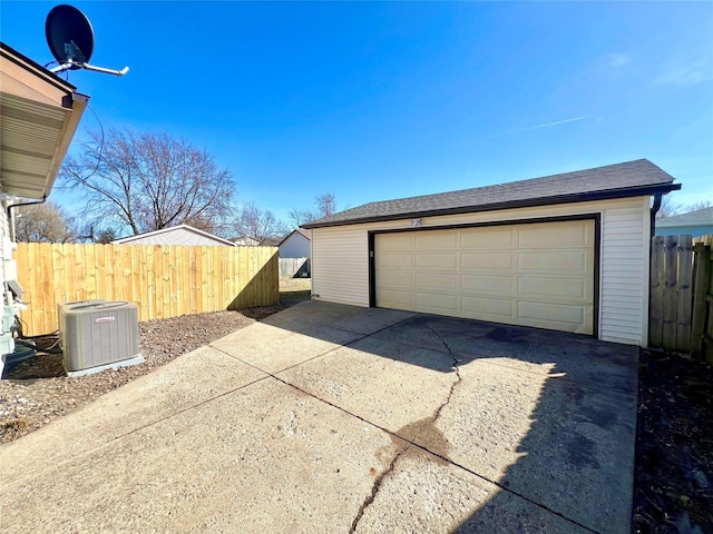 detached garage featuring cooling unit and fence