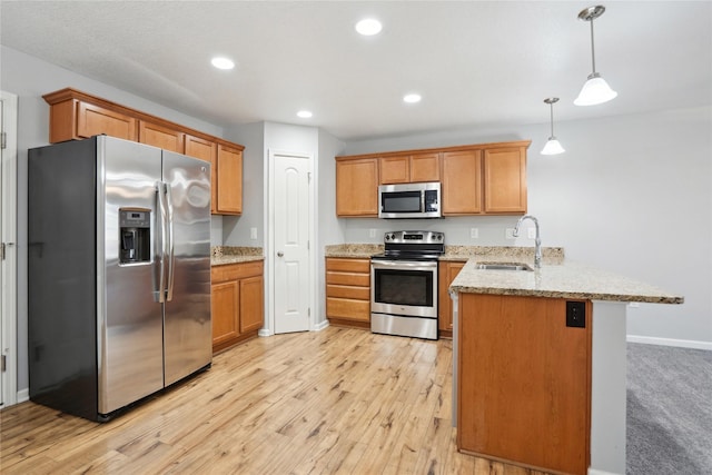 kitchen featuring light wood-style flooring, a sink, recessed lighting, stainless steel appliances, and a peninsula