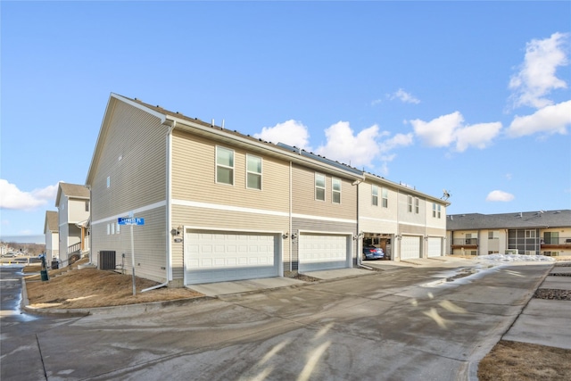 exterior space featuring an attached garage and central AC unit