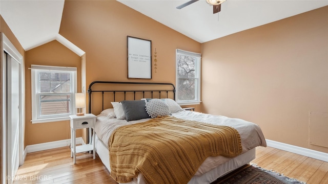 bedroom with baseboards, lofted ceiling, and hardwood / wood-style flooring