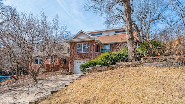 view of front of property with concrete driveway, a garage, and brick siding