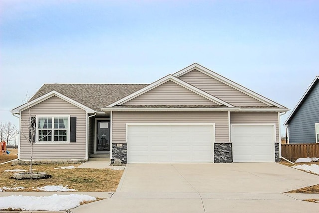 view of front of house featuring stone siding, concrete driveway, a garage, and a shingled roof