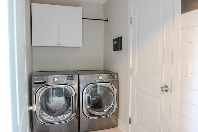 clothes washing area featuring cabinet space and independent washer and dryer