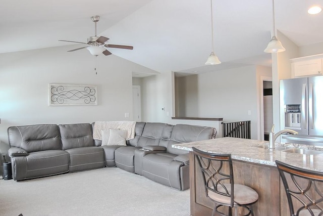 living room featuring a ceiling fan, carpet, and vaulted ceiling