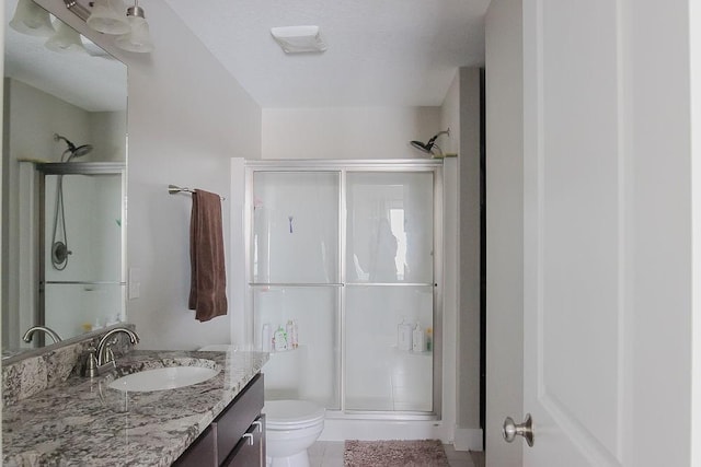 full bath with tile patterned floors, a stall shower, toilet, and vanity