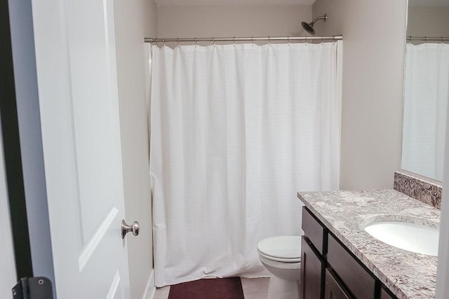 bathroom featuring vanity, a shower with shower curtain, and toilet