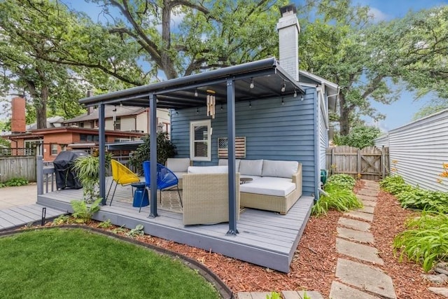 wooden terrace featuring area for grilling, outdoor lounge area, and fence