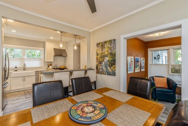 dining area with a ceiling fan, crown molding, recessed lighting, and light wood-style floors