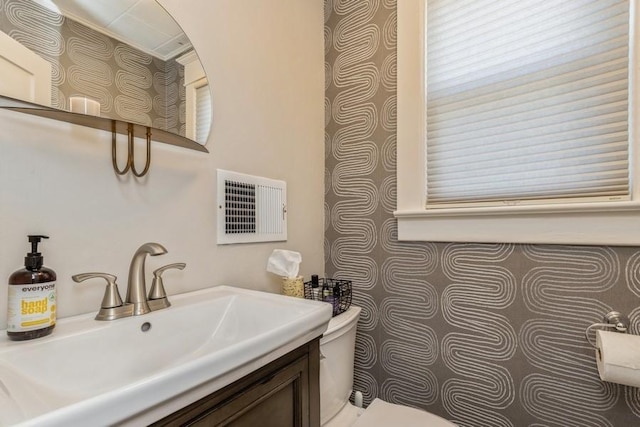 bathroom featuring visible vents, toilet, and vanity