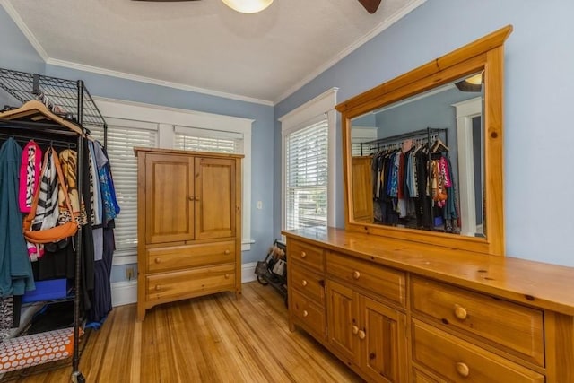 interior space with light wood finished floors, baseboards, a closet, and ornamental molding