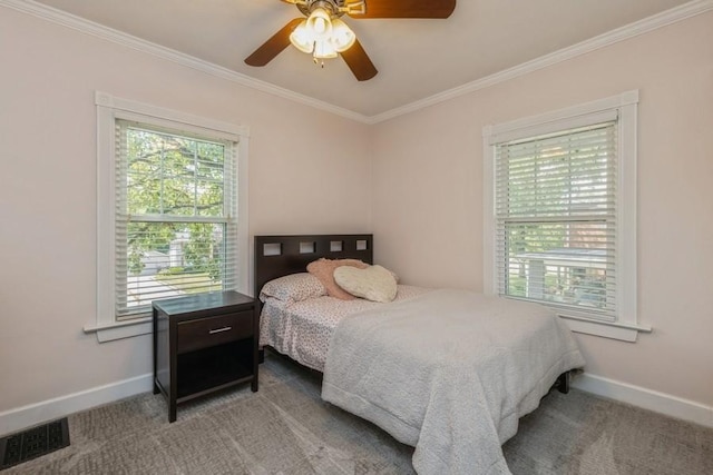 carpeted bedroom with visible vents, crown molding, and baseboards