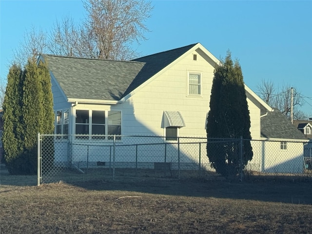 view of side of home featuring fence and roof with shingles