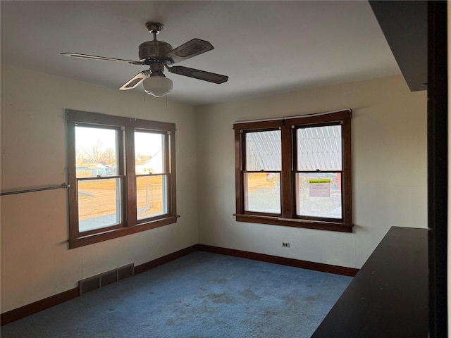 carpeted spare room with visible vents, ceiling fan, and baseboards