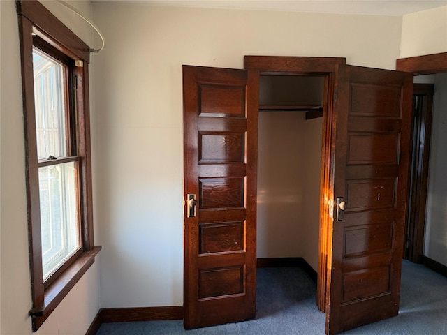 unfurnished bedroom featuring carpet flooring and baseboards