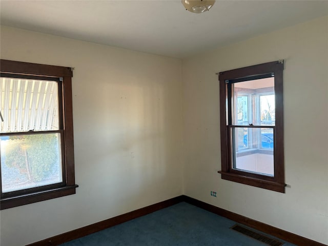 empty room featuring visible vents and baseboards