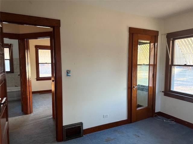 carpeted empty room with visible vents and baseboards