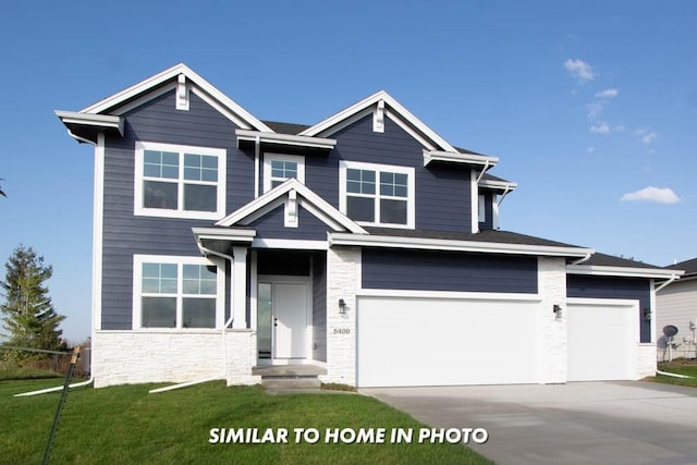 view of front of property featuring stone siding, a front lawn, an attached garage, and driveway