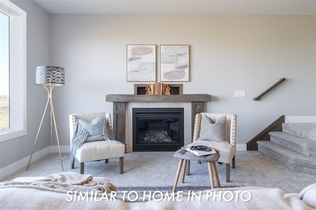 living area with stairway, a fireplace, baseboards, and carpet floors