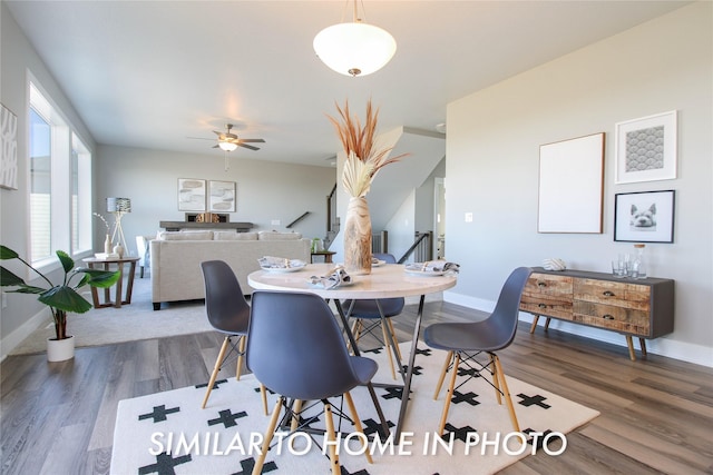 dining area featuring stairway, baseboards, wood finished floors, and a ceiling fan