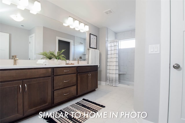 full bathroom with a sink, visible vents, tiled shower, and double vanity