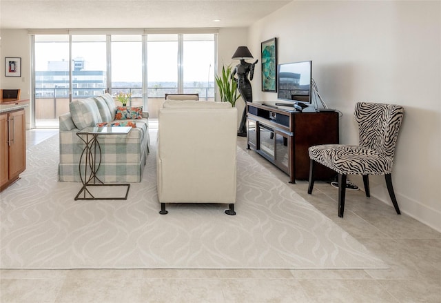 living room featuring light tile patterned floors, baseboards, and expansive windows