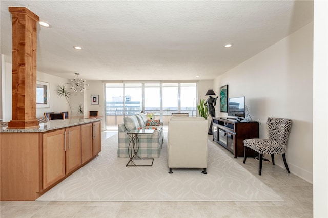 living room featuring a wall of windows, light tile patterned flooring, recessed lighting, and ornate columns