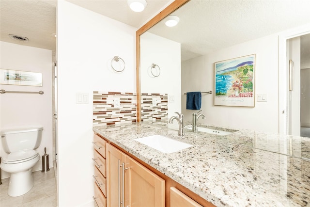 bathroom with vanity, tile patterned flooring, a textured ceiling, toilet, and backsplash