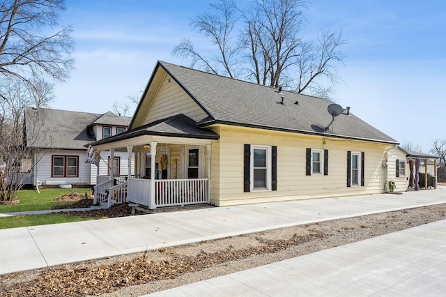 exterior space with covered porch and a shingled roof