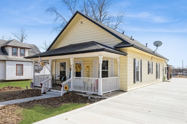 bungalow featuring covered porch and a shingled roof