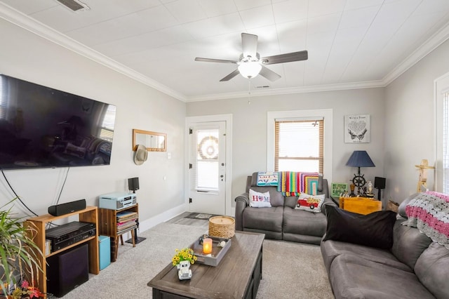 carpeted living area with ceiling fan, baseboards, and ornamental molding