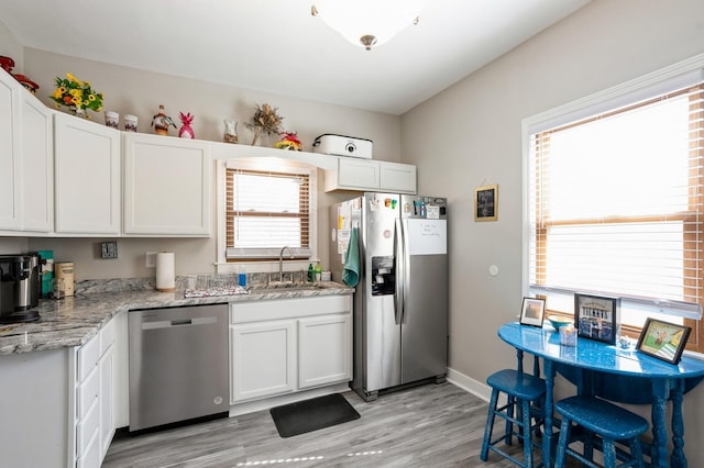 kitchen featuring a sink, stainless steel appliances, and white cabinets