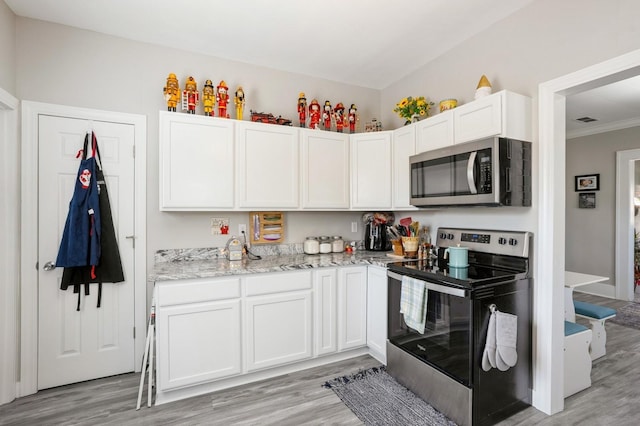 kitchen with visible vents, light stone counters, appliances with stainless steel finishes, light wood-style floors, and white cabinets