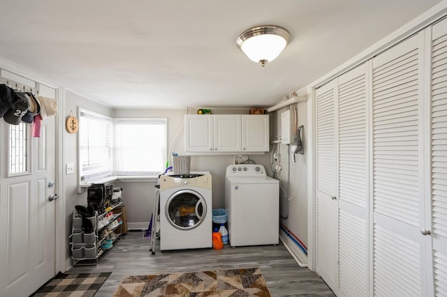 washroom with cabinet space, independent washer and dryer, baseboards, and wood finished floors