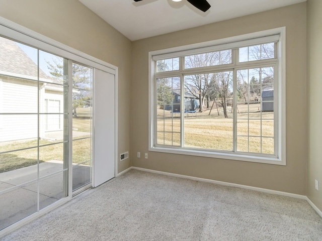 unfurnished room with visible vents, baseboards, carpet, and a ceiling fan