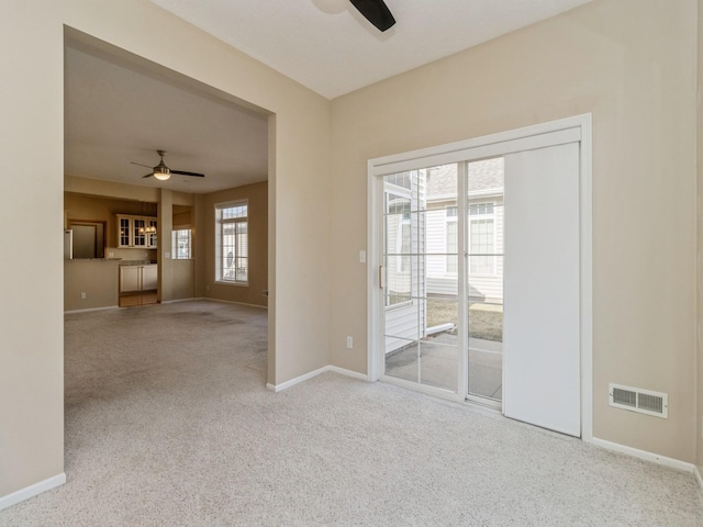 interior space featuring visible vents, carpet flooring, baseboards, and ceiling fan