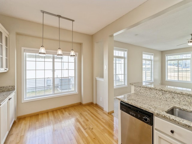 kitchen featuring light wood-style flooring, stainless steel dishwasher, white cabinetry, glass insert cabinets, and light stone countertops