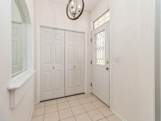 foyer with baseboards, arched walkways, and light tile patterned flooring